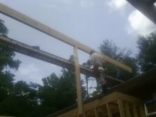 Carpenter setting a ridge beam over a new addition frame — Ice Dam Removal by Roofing Brothers in La Conner