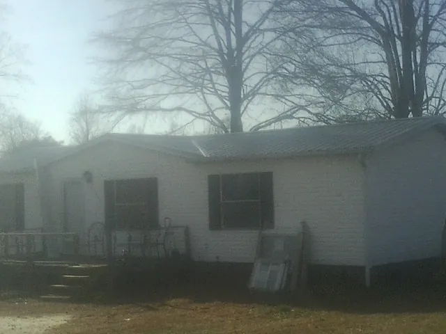 New metal roof on a white painted brick home on a foggy morning in La Conner